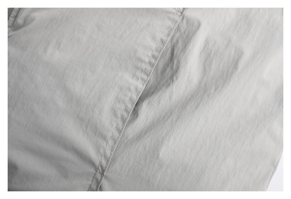 Close-up of light gray jacket fabric with a double-stitched seam.