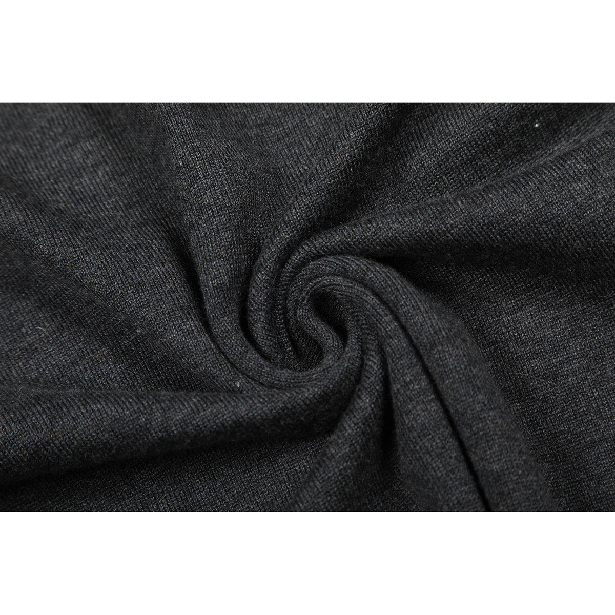 Close-up of charcoal knit fabric gathered into a spiral to show its texture.