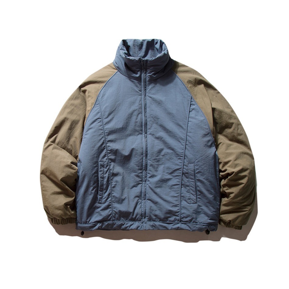 Blue-gray stand-collar zip jacket with olive-brown raglan sleeves, front view on a white background