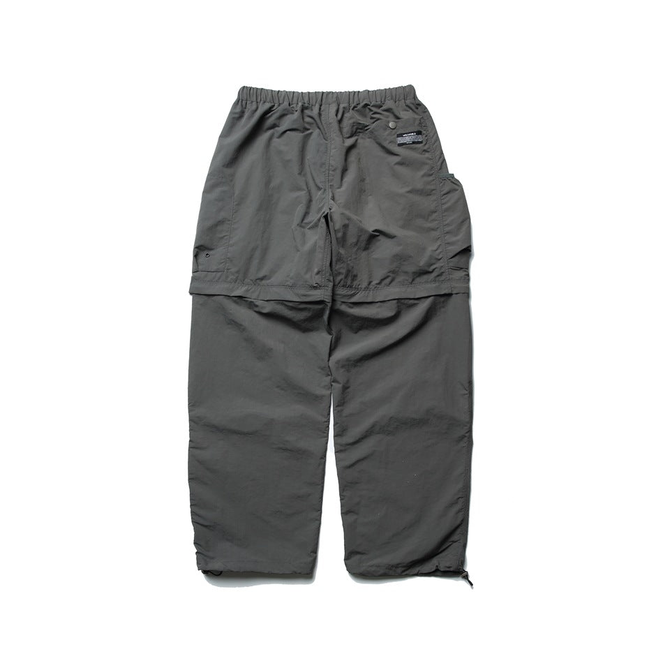 Dark gray wide-leg convertible pants back view with elastic waist, small label, snap tab and side pocket