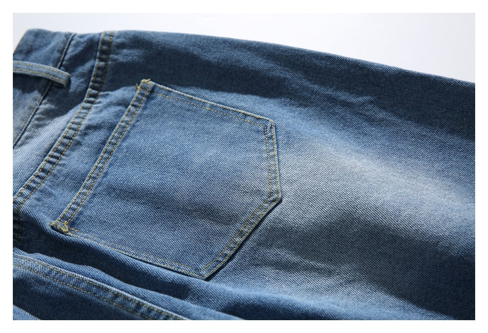 Close-up of a rear patch pocket and faded wash on blue denim jeans.