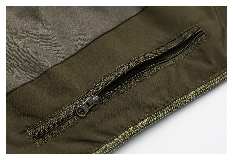 Close-up of an olive garment with a diagonal zippered pocket and stitched trim.