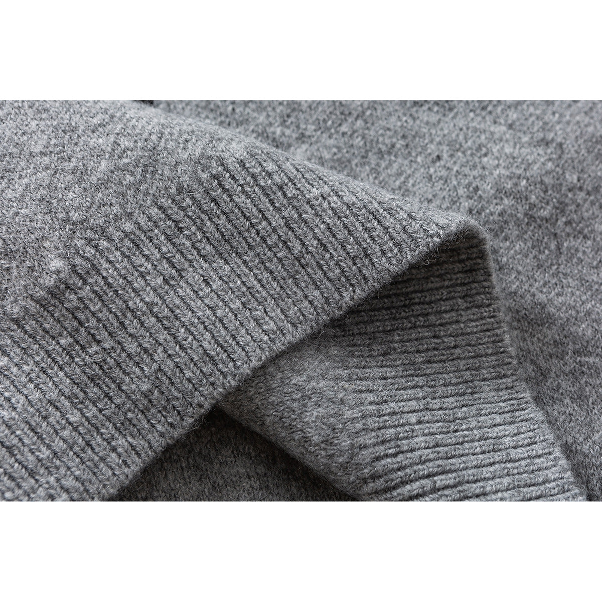 Close-up of the gray cardigan's knit texture and folded ribbed cuff.