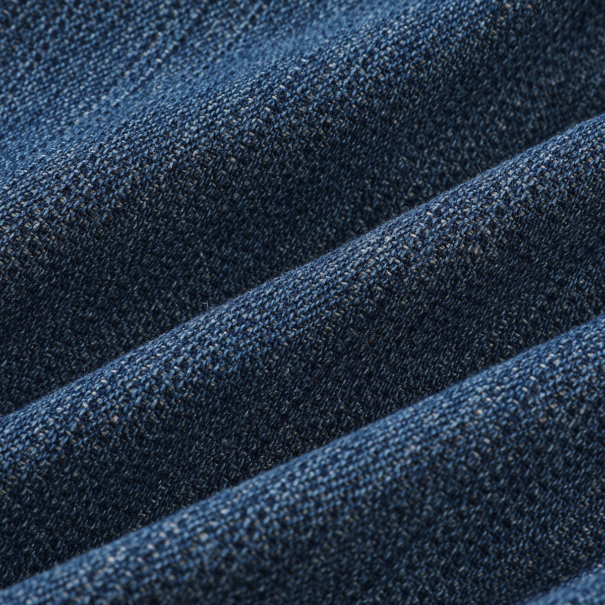 Close-up showing the textured weave and folded seams of dark blue denim.