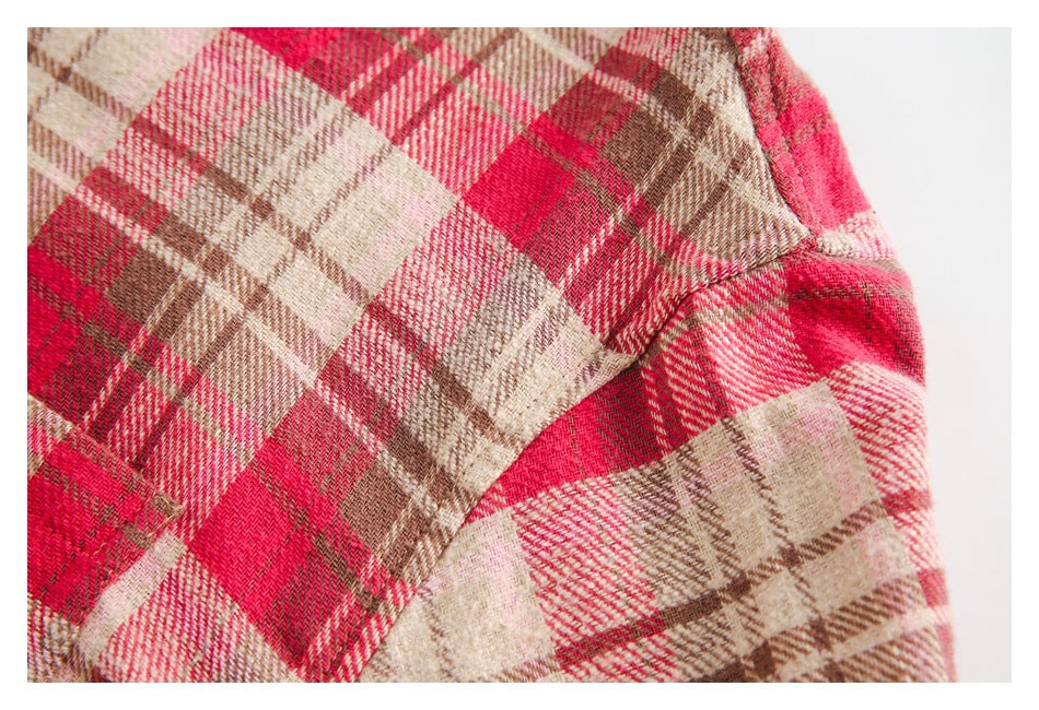 Close-up of the plaid garment's sleeve seam in red, cream, and brown checks.