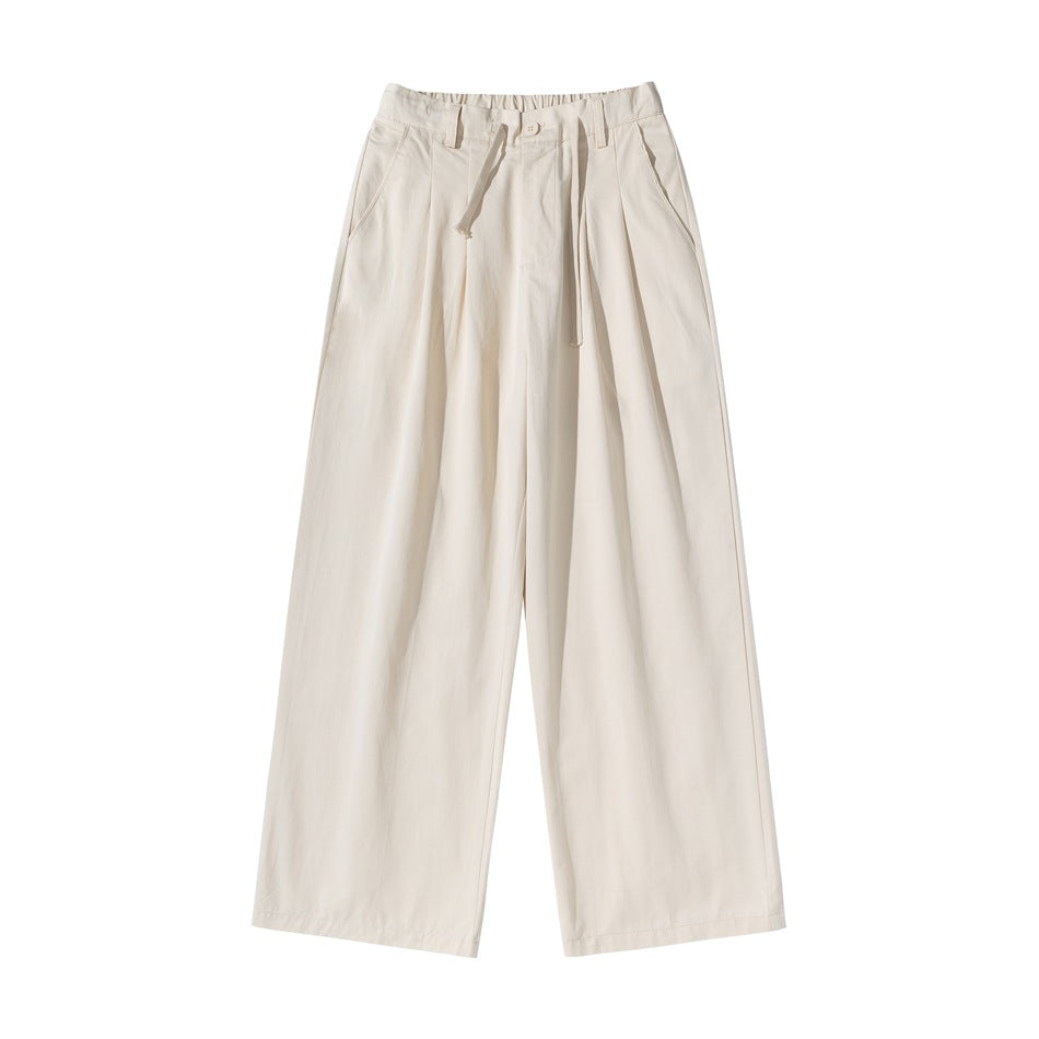 Beige apricot wide-leg pleated pants with elastic waistband, drawstring and slant pockets, flat lay front view