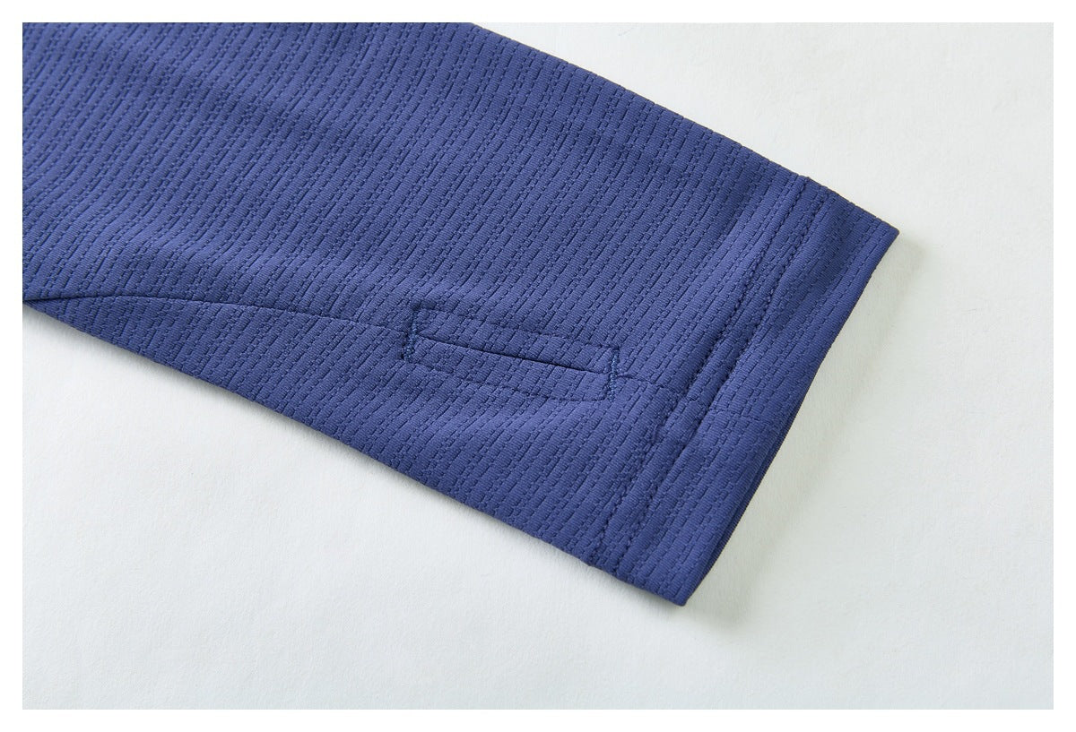 Close-up of a blue shirt sleeve hem showing its stitching and textured fabric.