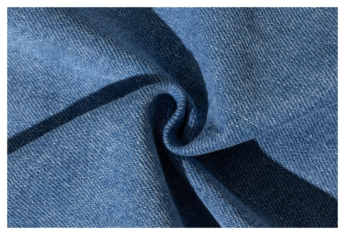 Close-up of blue denim fabric gathered into a fold, showing its diagonal weave.