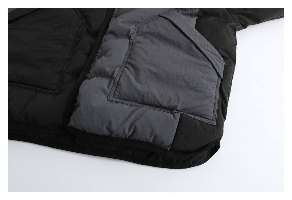 Close-up of a large flap pocket on the black and charcoal quilted jacket.