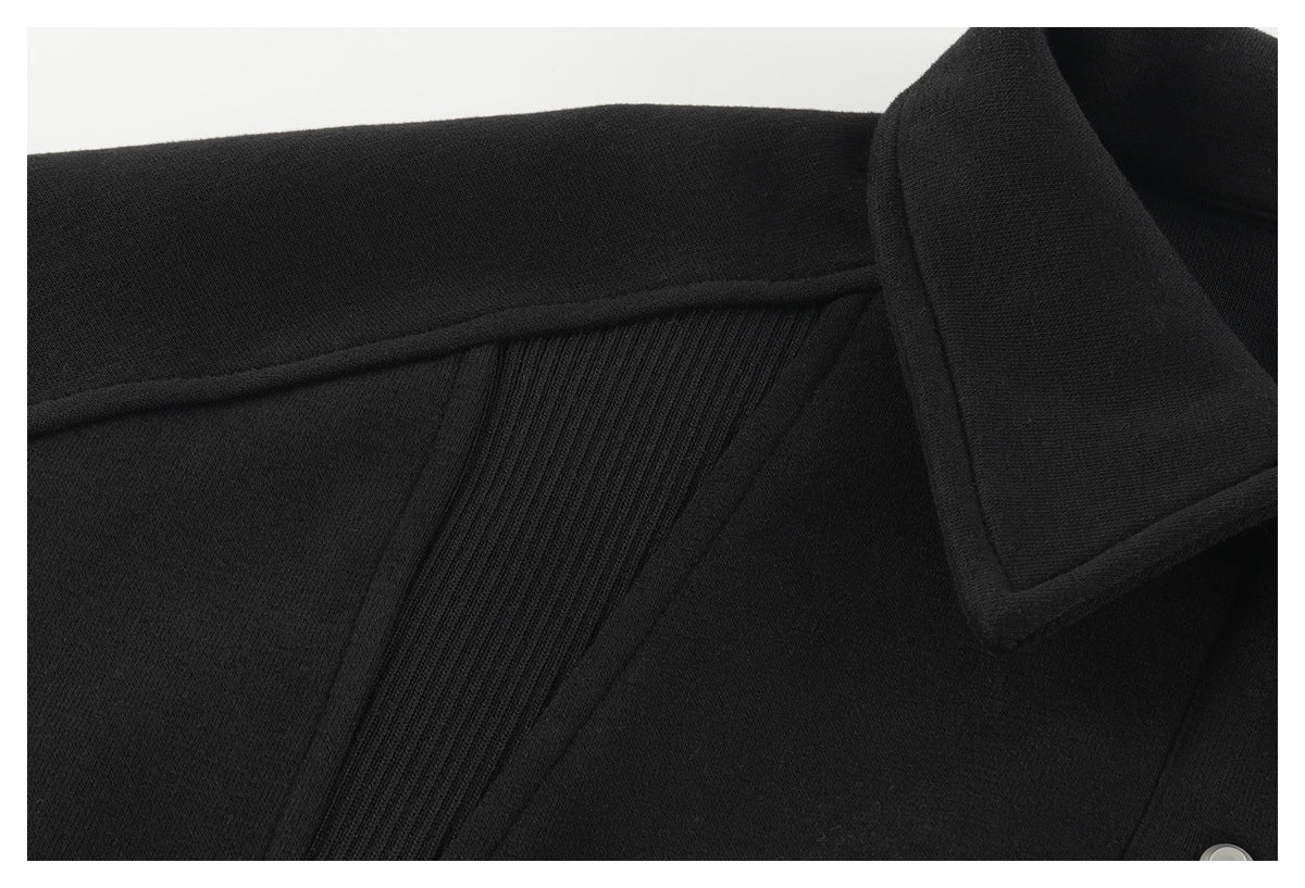 Close-up of a black garment's collar and ribbed panel detail.