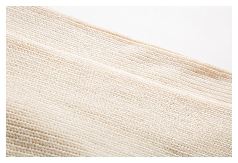 Close-up of the ivory garment's raised knit texture and stitch pattern.