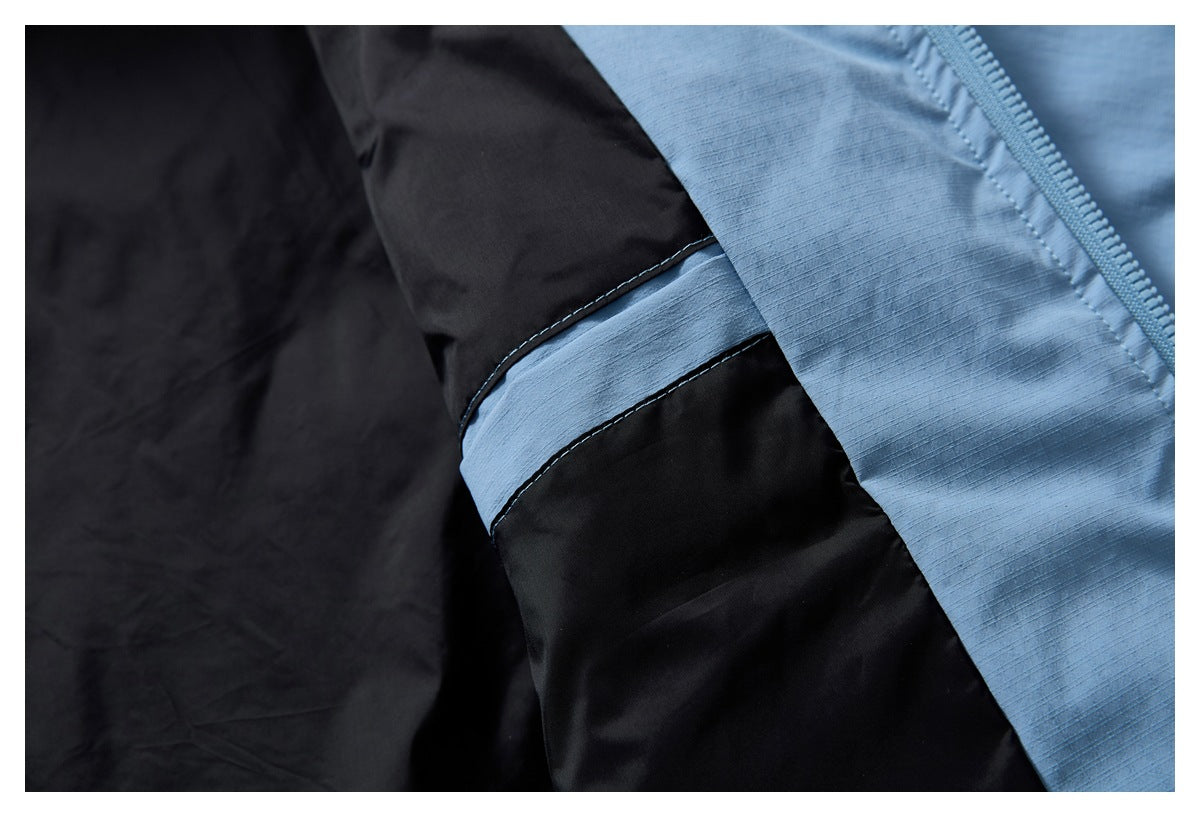 Close-up of the jacket's black lining beside light blue shell fabric and a contrasting sleeve band.