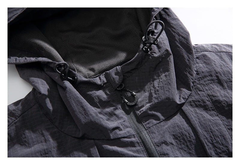 Close-up of the dark gray jacket's hood drawcords, front zipper, and fabric.