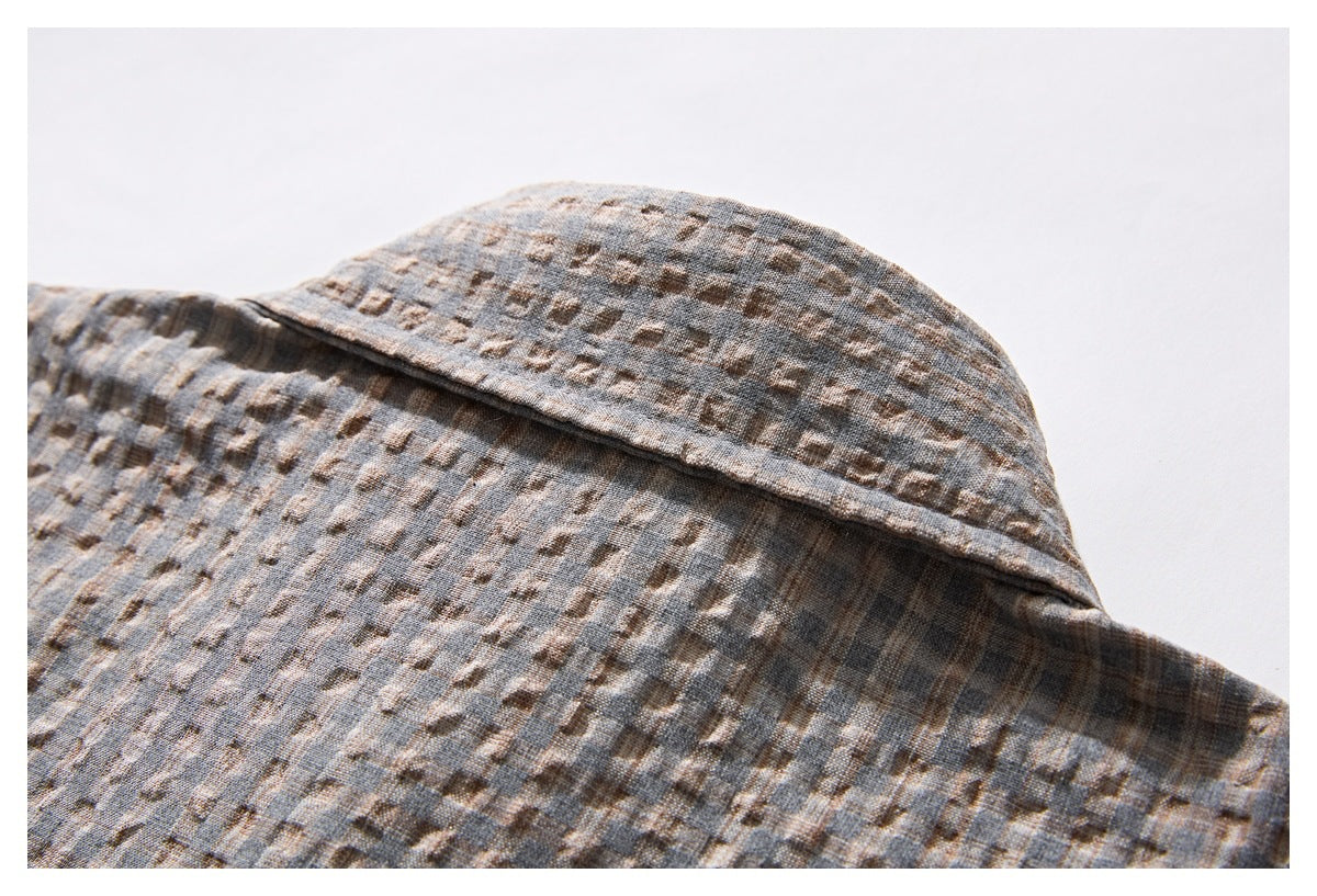 Close-up of the gray-brown patterned shirt collar and neckline.