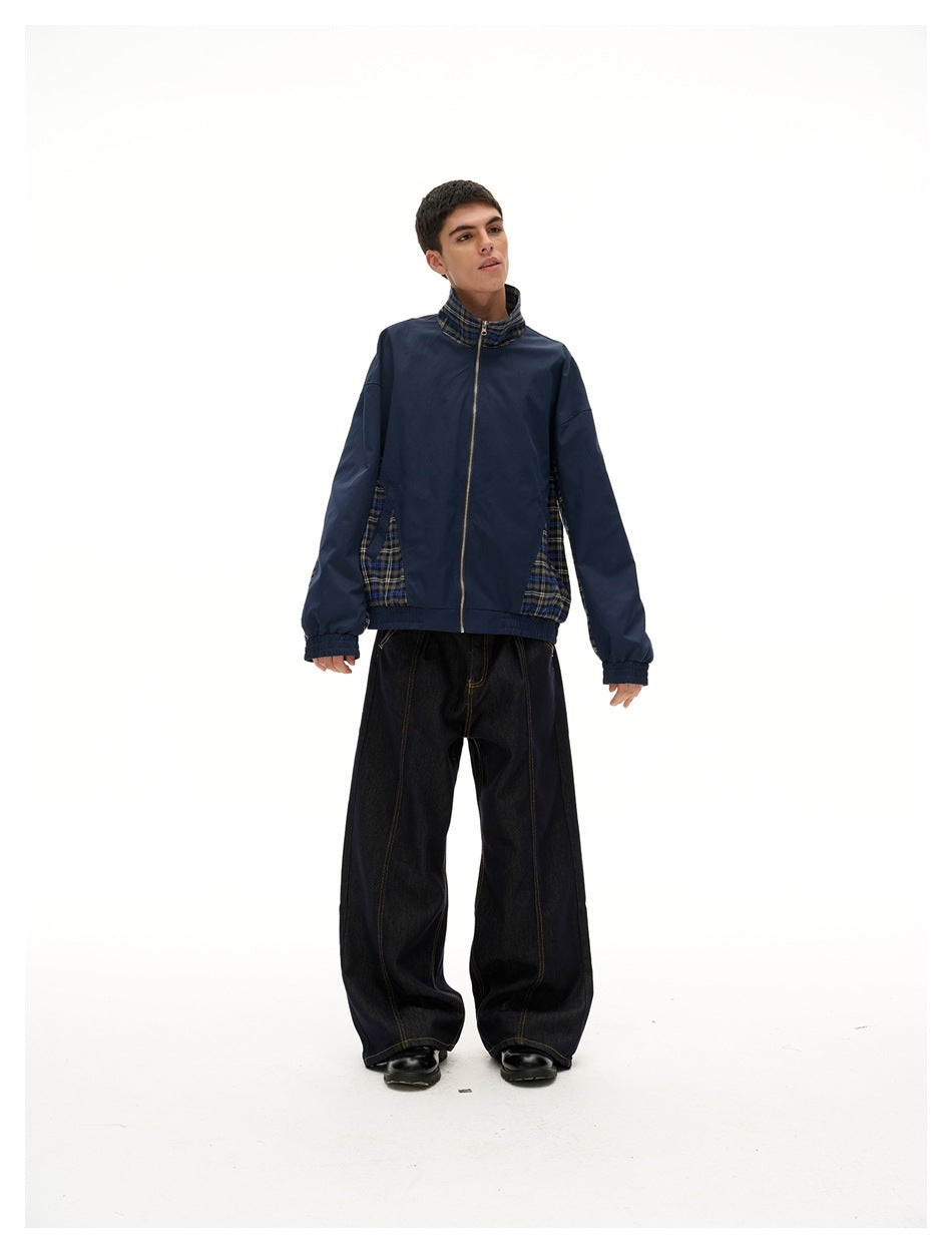 Model wearing navy plaid-panel zip jacket with wide dark jeans and black shoes, front view