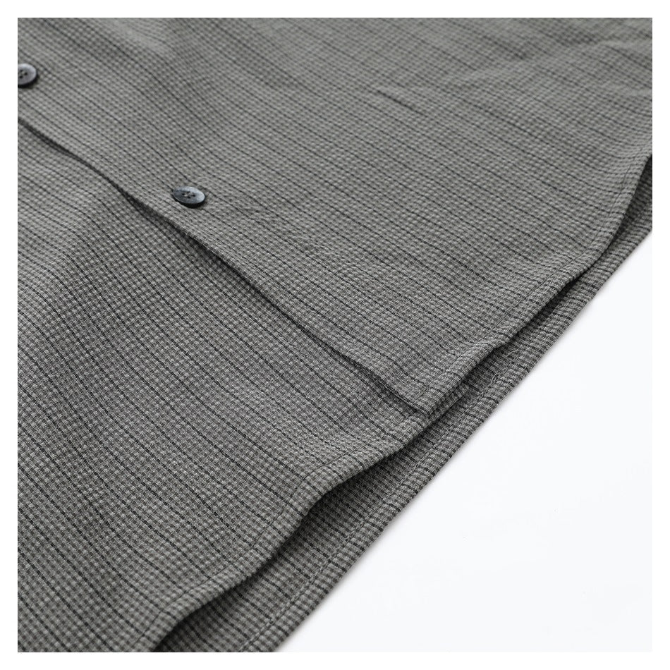 Close-up of the gray micro-check shirt front, showing buttons and a stitched edge.