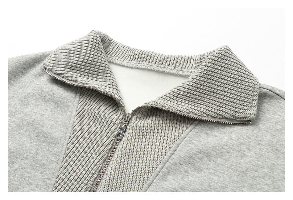 Close-up of a light gray jacket's wide ribbed collar and front zipper.