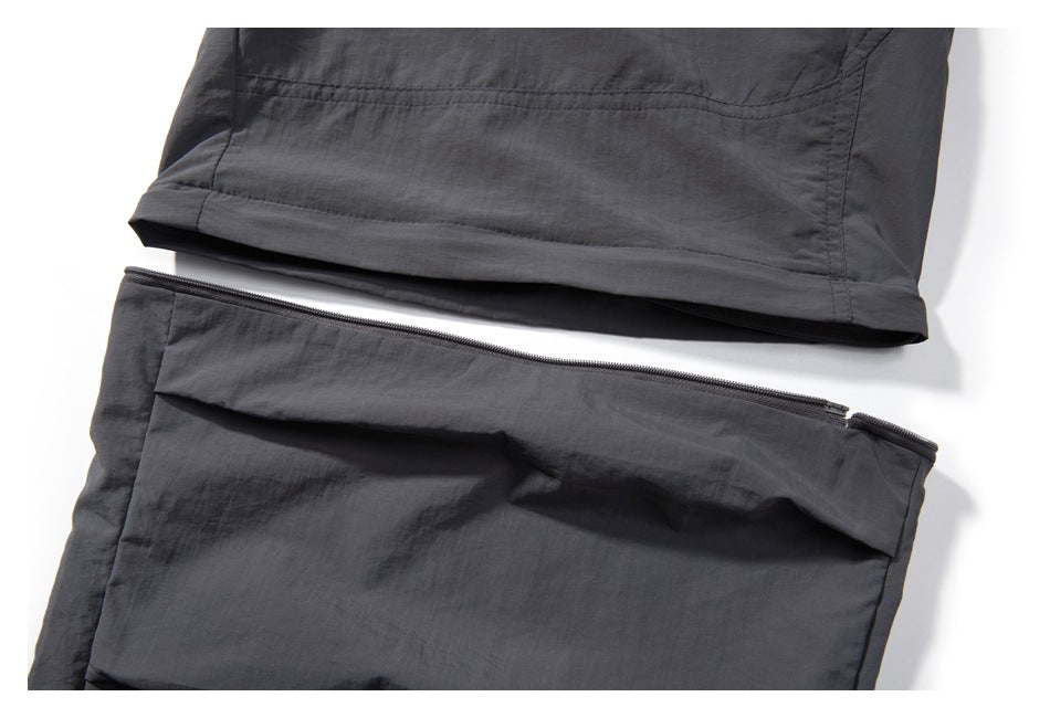 Dark charcoal pants shown with a long zipper separating two sections of the garment.