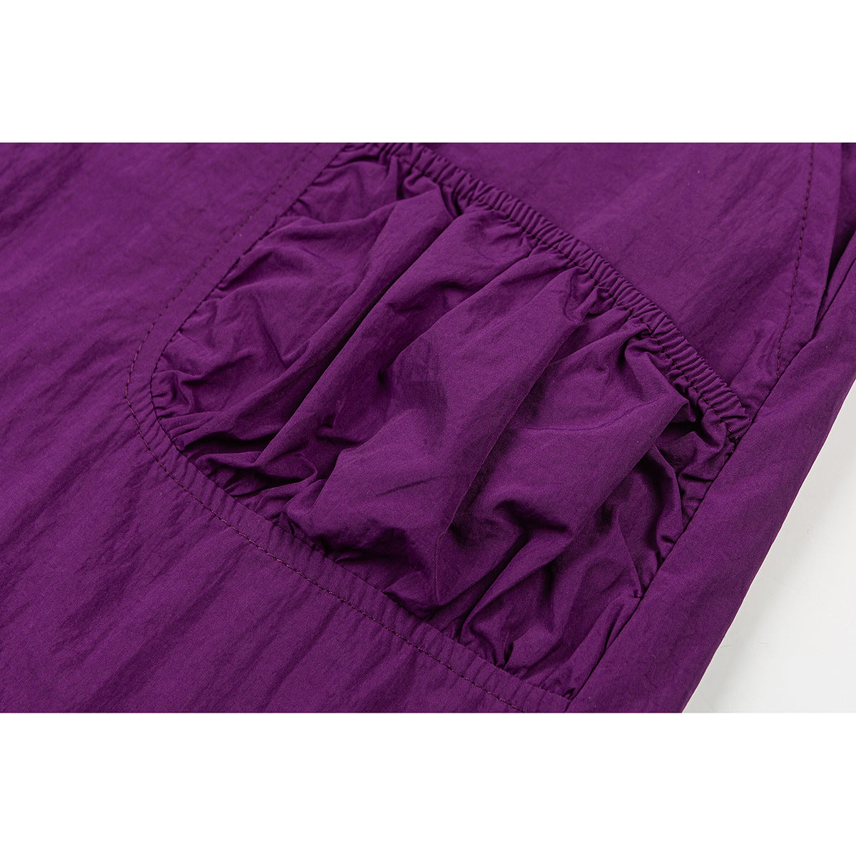 Close-up of a gathered pocket on a purple skirt.