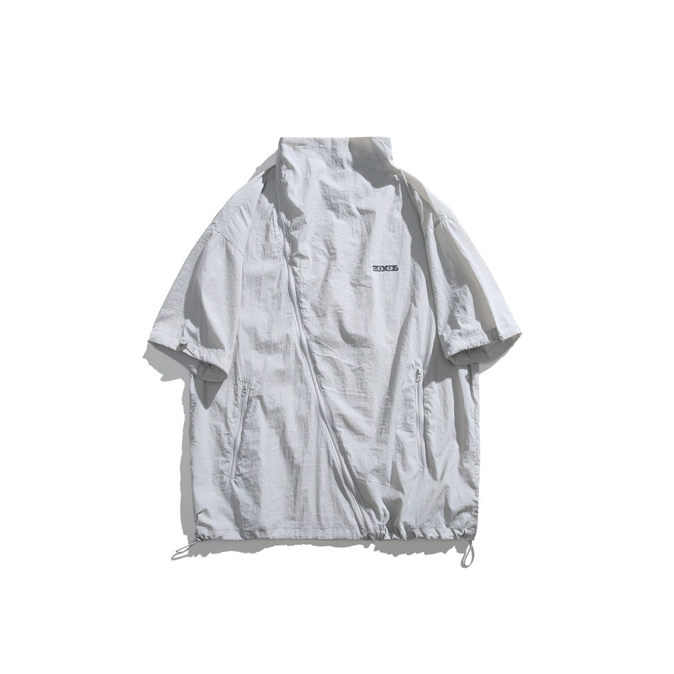 Light gray short-sleeve stand-collar jacket flat lay with diagonal zipper, zip pockets and drawstring hem