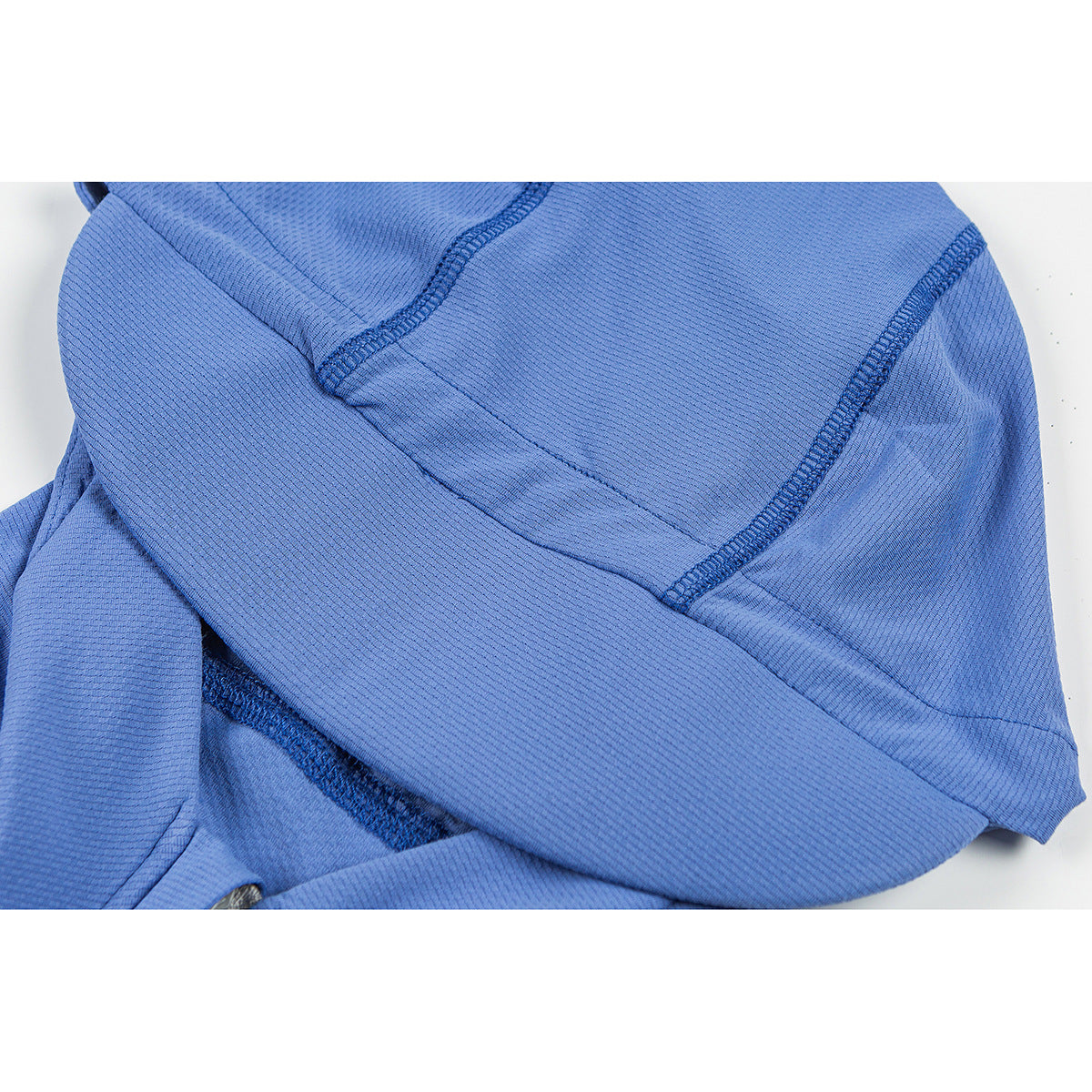 Close-up of the blue jacket’s textured surface and curved stitched seams.