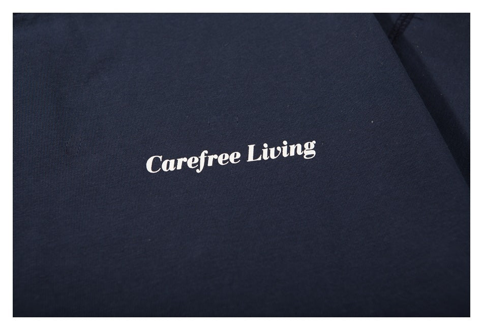 Close-up of white “Carefree Living” lettering printed on navy T-shirt fabric.