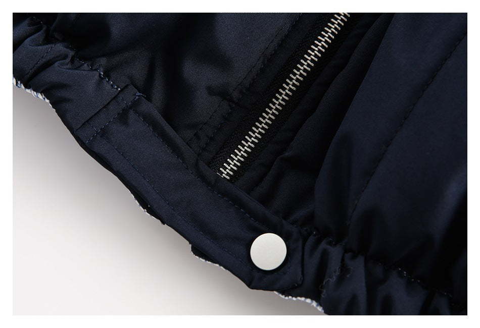 Close-up of a navy garment with a silver zipper and white snap fastener.