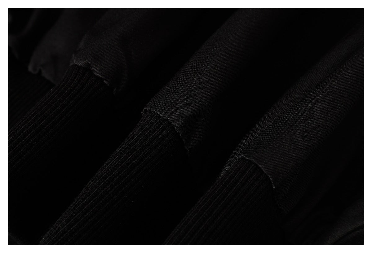 Very close view of black fabric and ribbed cuff sections.