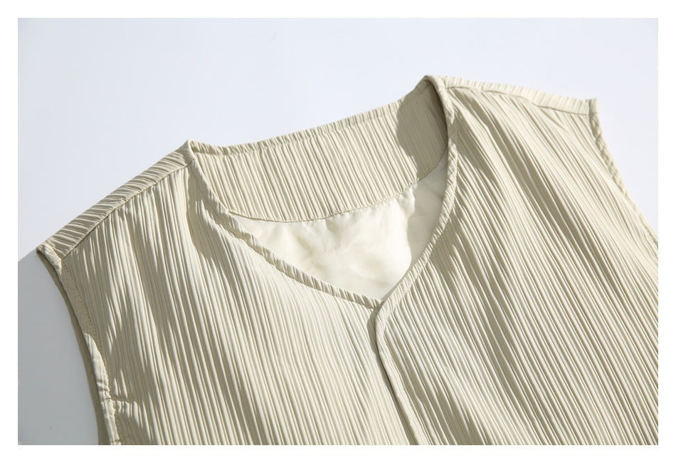 Close-up of the light beige vest's ribbed fabric and V-neck opening.