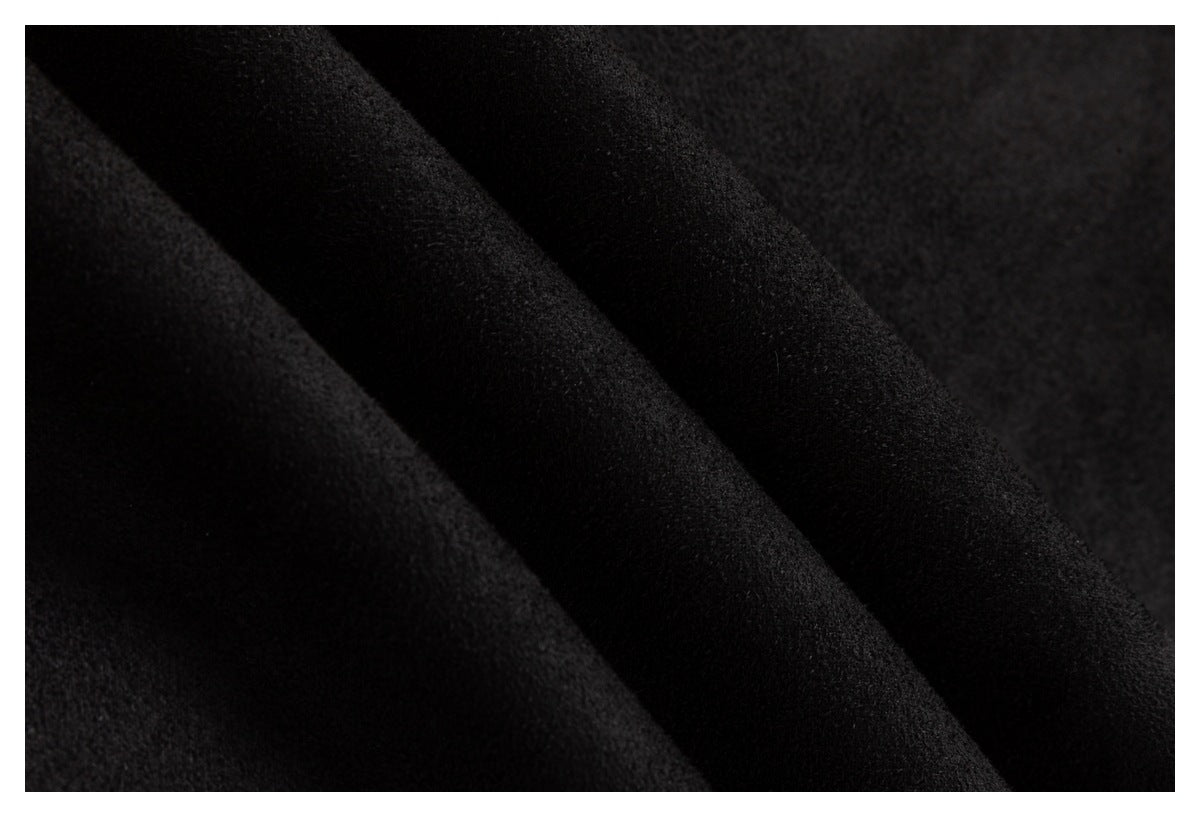 Macro view of black garment fabric showing its soft-looking surface and folds.