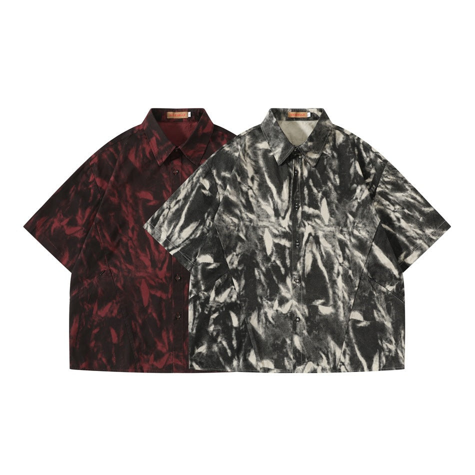Two short-sleeve button-up shirts shown from the front in black and cream, and dark red abstract patterns.