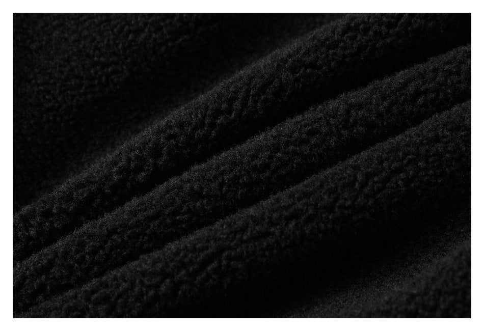 Close-up of black fuzzy fabric with a dense, raised texture.