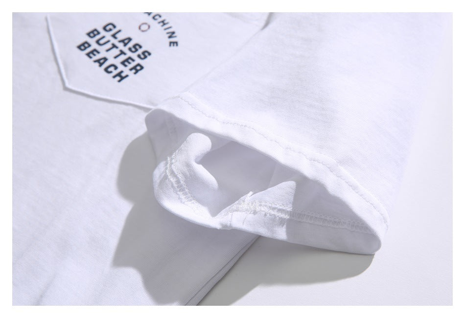 Close-up of the white T-shirt's short sleeve cuff and stitching, with part of the printed chest pocket visible.