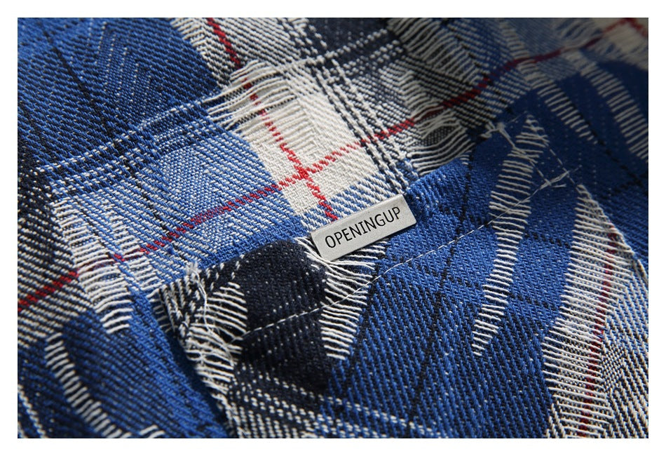 Close-up of blue, black, and cream plaid fabric with a small sewn label reading OPENINGUP.