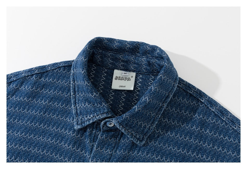 Close-up of the shirt collar and sewn-in label on blue zigzag-patterned fabric.