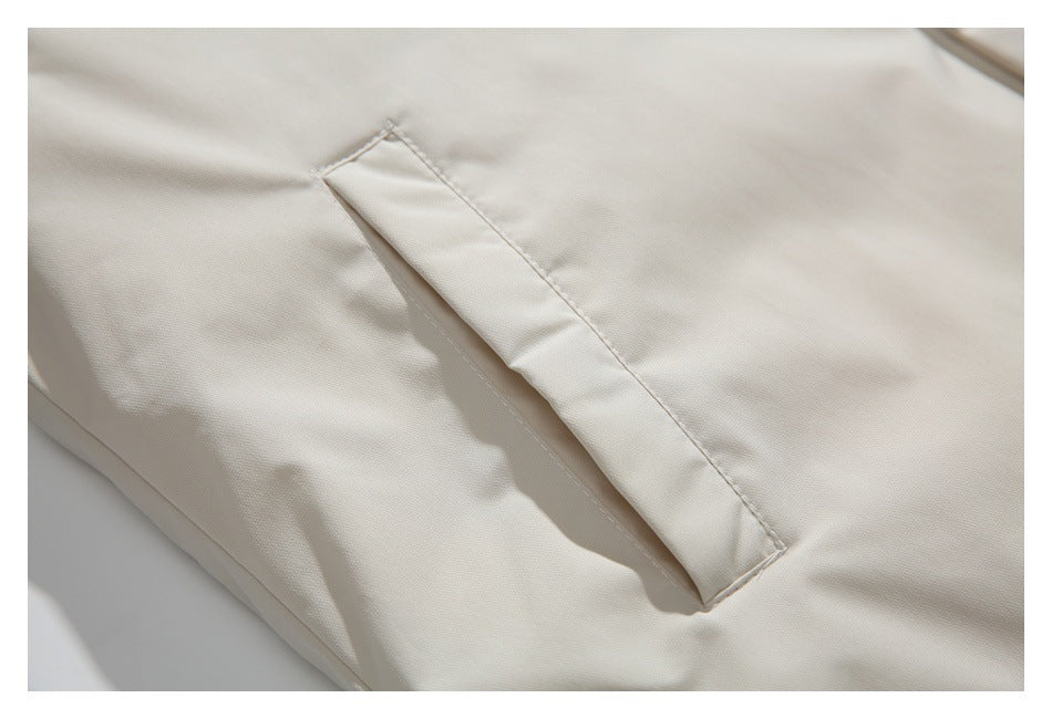 Close-up of a narrow welt pocket on the smooth ivory jacket fabric.