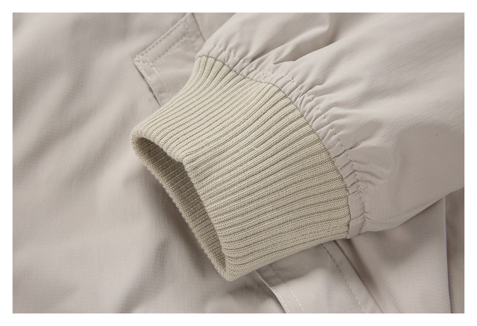 Close-up of a ribbed knit cuff on the sleeve of a light beige garment.