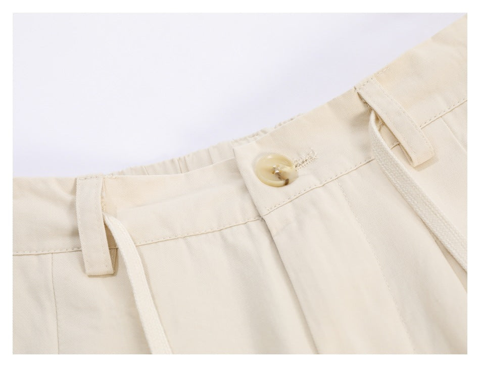 Close-up of the ivory trousers' waistband, button, belt loop, stitching and drawstring.