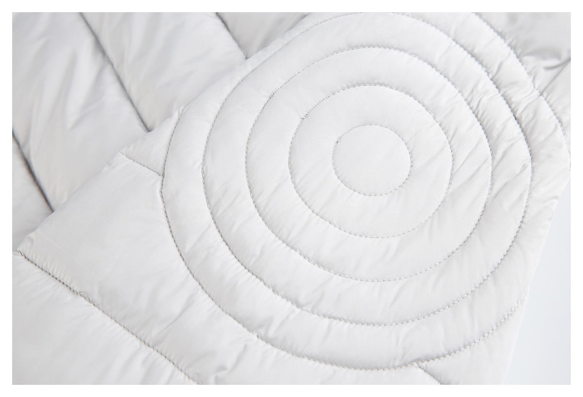 Close-up showing concentric circular quilting on a light gray padded garment.