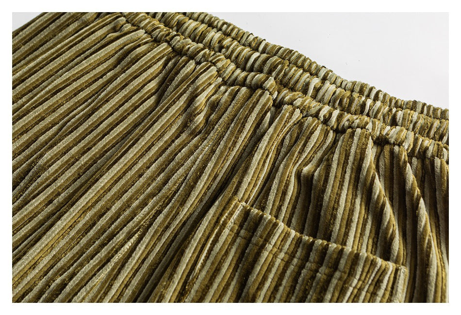 Close-up of olive and tan striped corduroy pants showing the elastic waist and a front pocket.