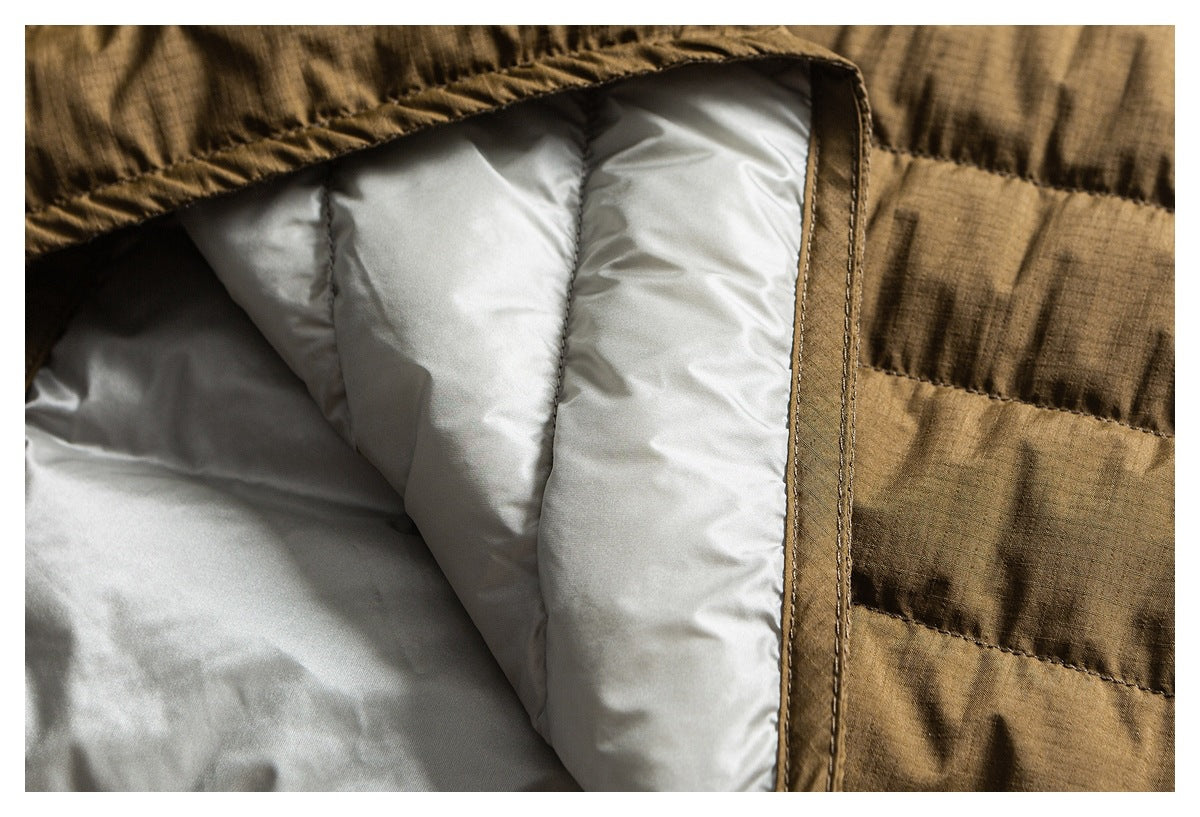 Close-up of pale padded lining inside a brown quilted jacket, with the bound opening edge visible.