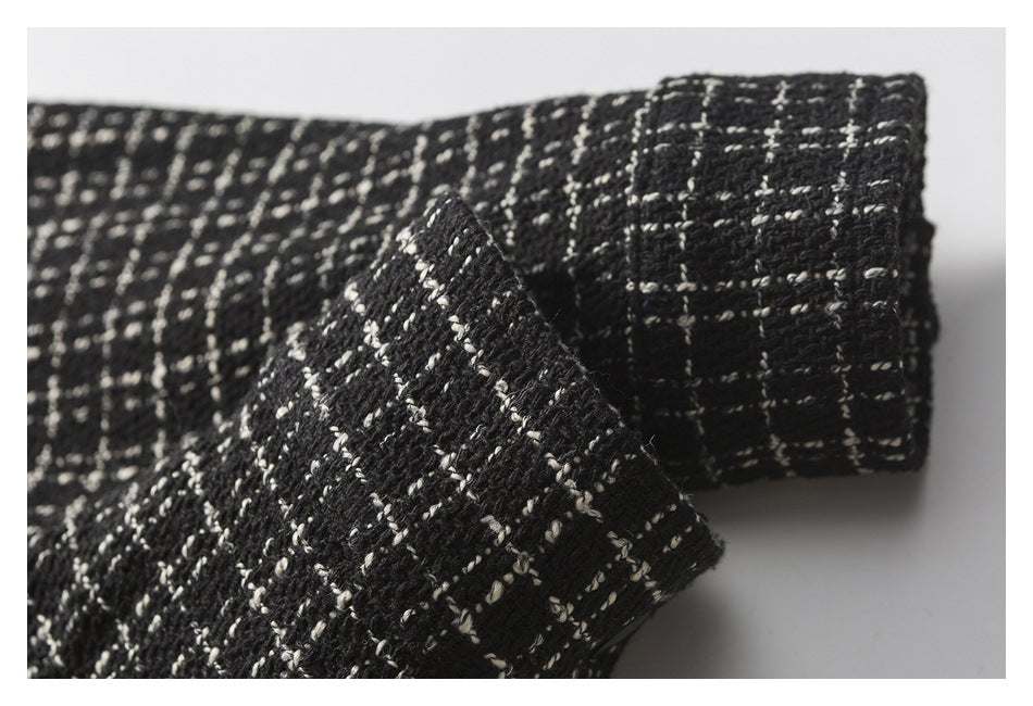 Close-up of a folded edge in black-and-cream textured fabric.