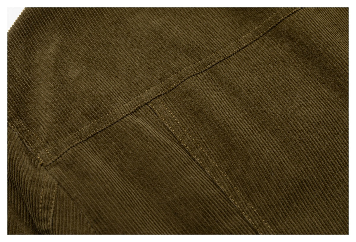 Close-up of olive-brown corduroy fabric, showcasing a curved seam and panel stitching.