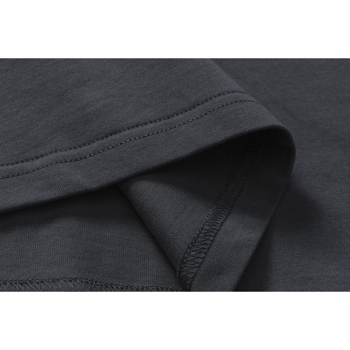 Close-up of the dark charcoal T-shirt's stitched sleeve hem and overlocked interior seam.