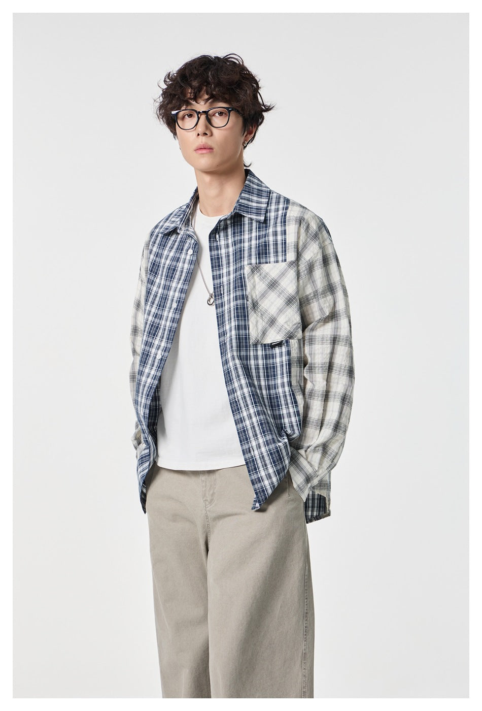 Model wearing an open navy and gray mixed-plaid shirt over a white tee, shown from the front.