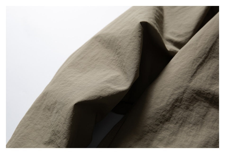 Close-up of an olive-brown jacket sleeve and adjacent body fabric.
