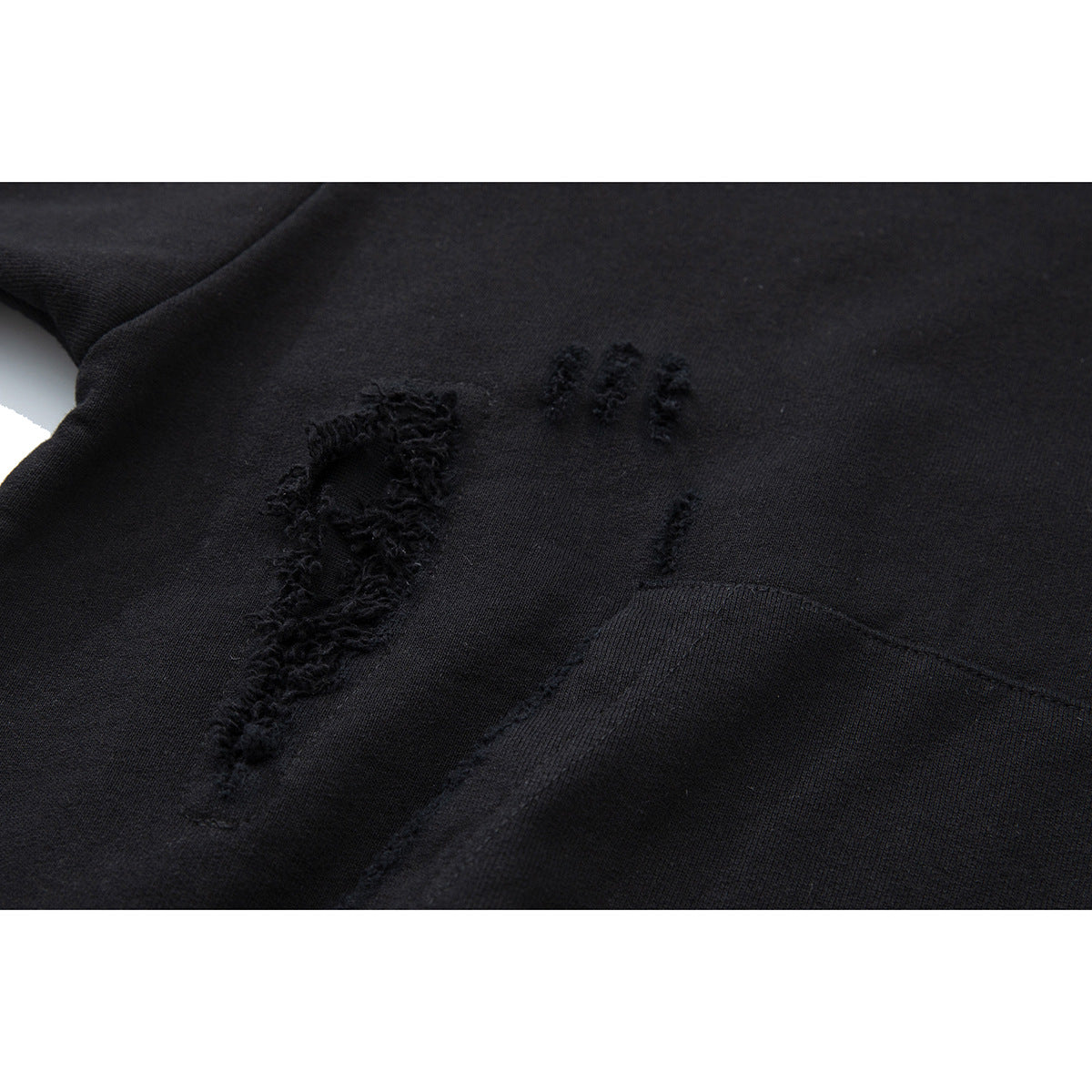 Close-up of distressed black fabric and the kangaroo pocket on a hooded pullover.