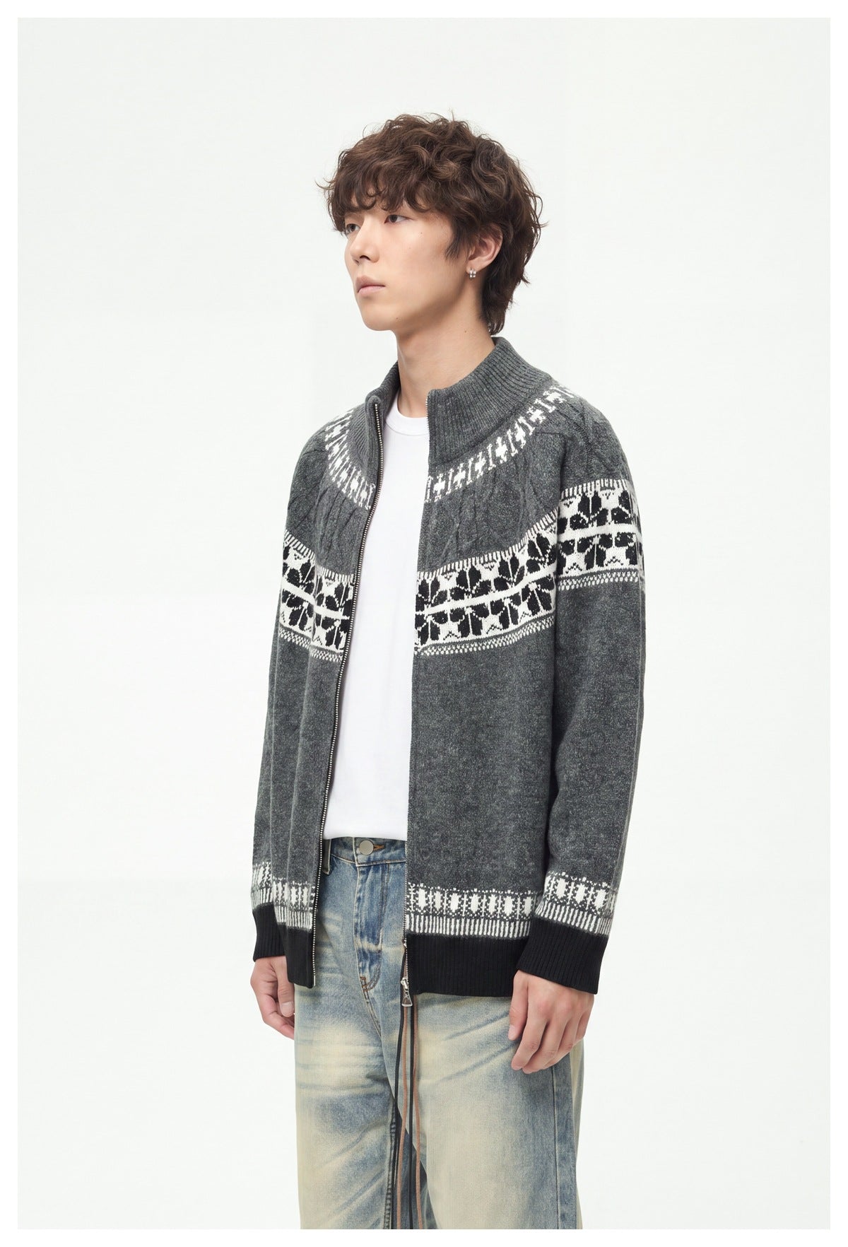 Three-quarter side view of a model wearing an open charcoal knit cardigan with a high collar and white patterned bands.