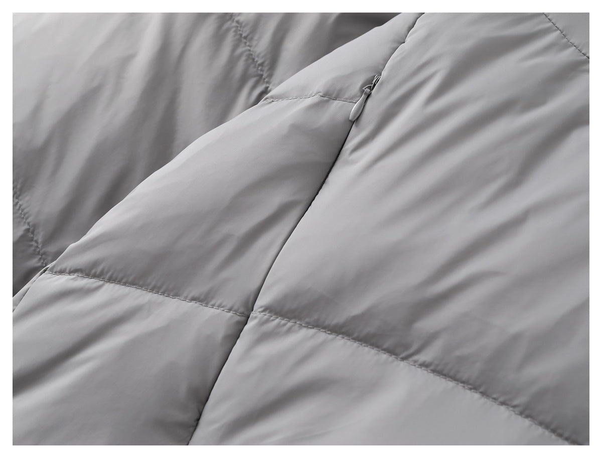 Close-up of gray quilted jacket panels and a discreet angled zip pocket.
