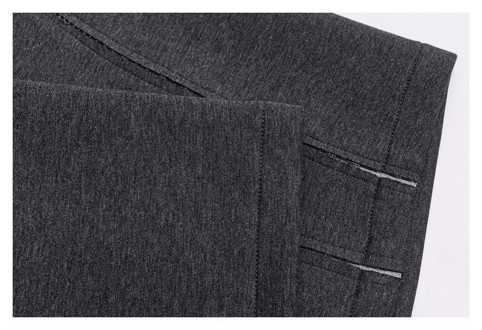 Close-up of charcoal gray jogger pants showing overlapping fabric panels and stitched openings.